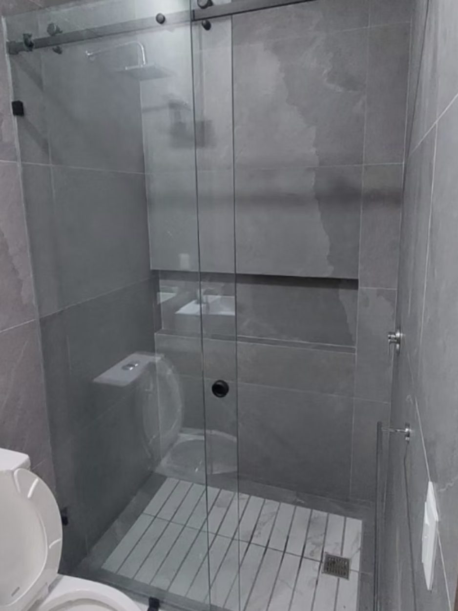 Cancel corredizo de vidrio templado en un baño gris