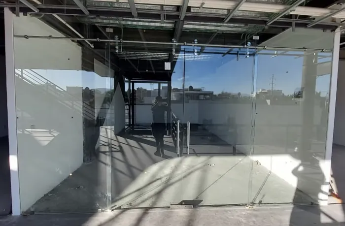 Frente de local con puerta abatible de cristal templado
