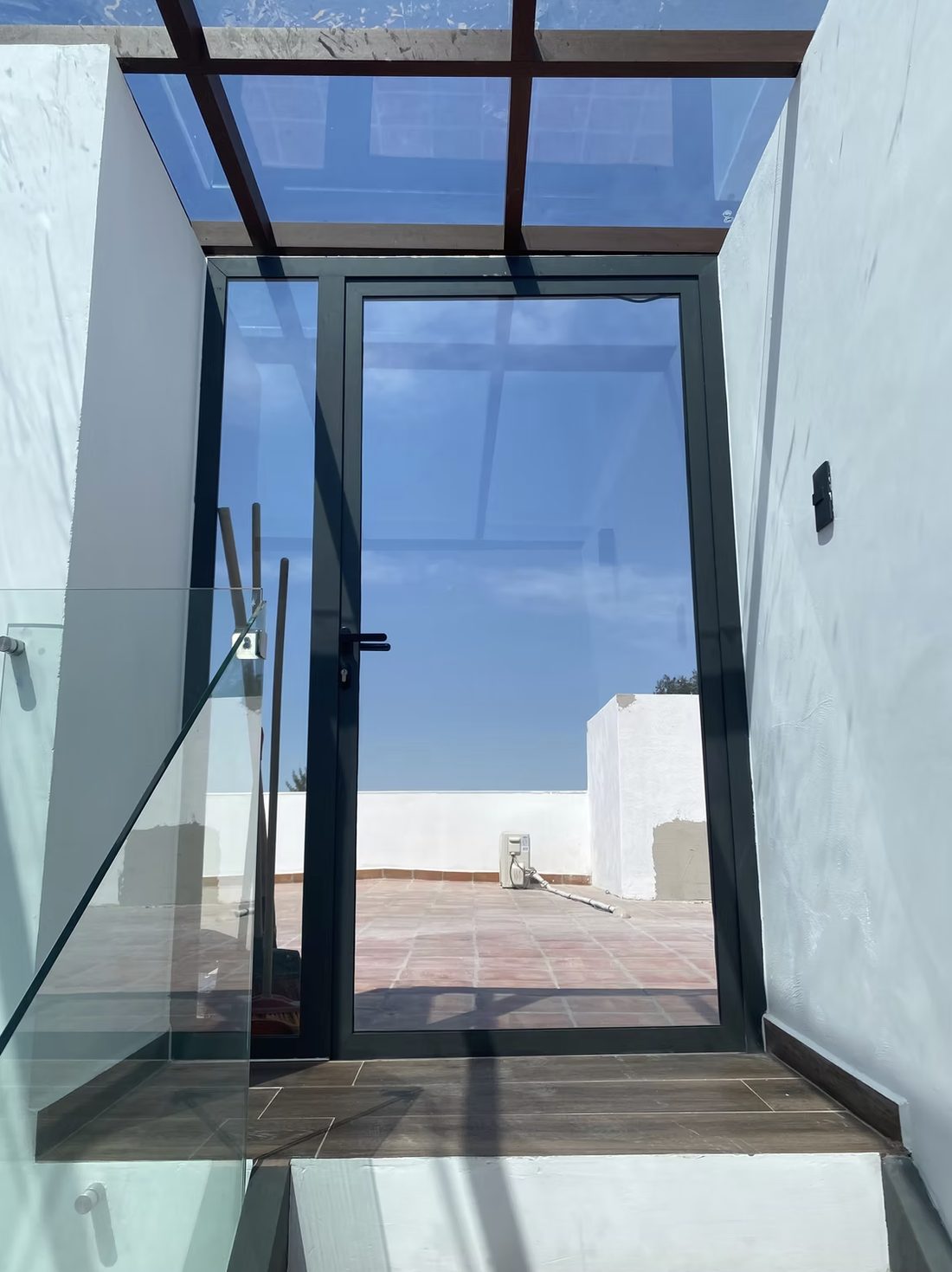 Techo de cristal y barandal de vidrio templado en una terraza